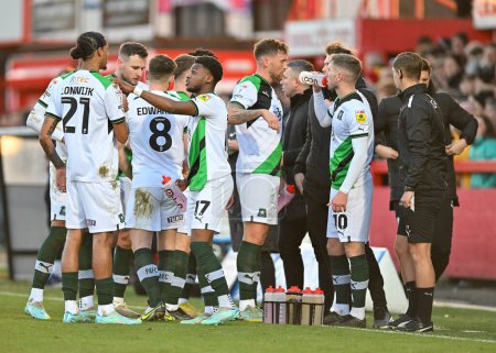 Photo for Plymouth Argyle players in the dugout  during the Sky Bet League 1 match Cheltenham Town vs Plymouth Argyle at The Jonny-Rocks Stadium, Cheltenham, United Kingdom, 26th December 202 - Royalty Free Image