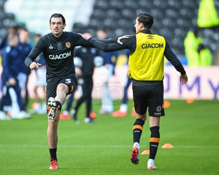 Photo for Jacob Greaves #4 and Alfie Jones #5 of Hull City stretch during the pre-game warmup ahead of the Sky Bet Championship match Hull City vs Blackpool at MKM Stadium, Hull, United Kingdom, 26th December 202 - Royalty Free Image