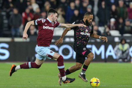 Photo for Rico Henry #3 of Brentford gets away from Declan Rice #41 of West Ham United during the Premier League match West Ham United vs Brentford at London Stadium, London, United Kingdom, 30th December 202 - Royalty Free Image