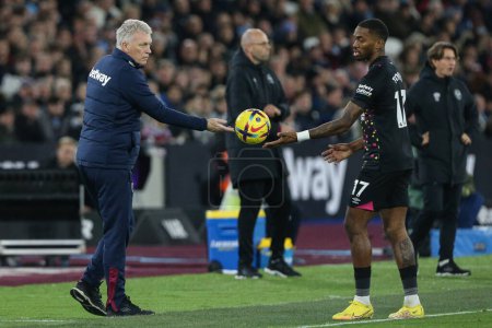 Photo for David Moyes manager of West Ham United passes the ball to Ivan Toney #17 of Brentford during the Premier League match West Ham United vs Brentford at London Stadium, London, United Kingdom, 30th December 202 - Royalty Free Image