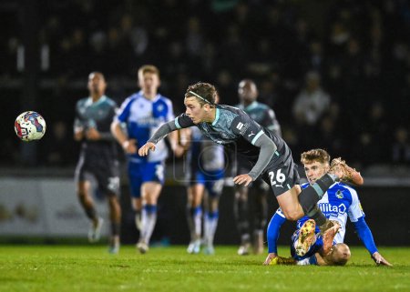Photo for Plymouth Argyle midfielder Callum Wright (26)  attacking with the ball  and is fouled by Bristol Rovers  midfielder Glenn Whelan  (25)  during the Papa John's Trophy match Bristol Rovers vs Plymouth Argyle at Memorial Stadium, Bristol, United Kingdom - Royalty Free Image
