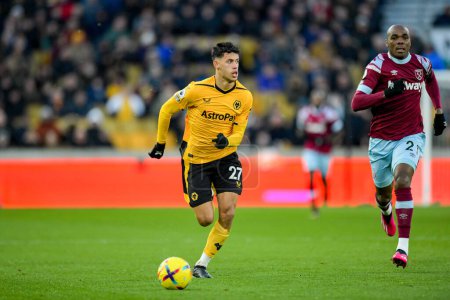 Téléchargez les photos : Matheus Nunes #27 of Wolverhampton Wanderers makes a run with the ball chased by Angelo Ogbonna #21 of West Ham United during the Premier League match Wolverhampton Wanderers vs West Ham United at Molineux, Wolverhampton, United Kingdom, 14th January - en image libre de droit