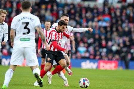 Photo for Patrick Roberts #10  of Sunderland battles Ryan Manning #3 of Swansea City and Harry Darling #6 of Swansea City during the Sky Bet Championship match Sunderland vs Swansea City at Stadium Of Light, Sunderland, United Kingdom, 14th January 202 - Royalty Free Image
