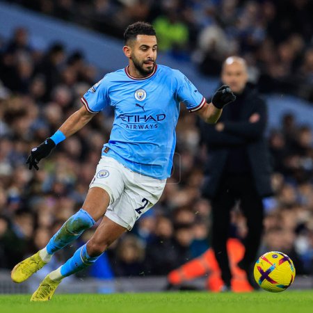 Foto de Riyad Mahrez #26 of Manchester City in action with Pep Guardiola manager of Manchester City looking on during the Premier League match Manchester City vs Tottenham Hotspur at Etihad Stadium, Manchester, United Kingdom, 19th January 202 - Imagen libre de derechos