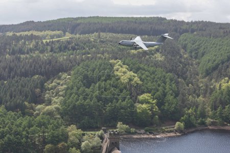 Photo for An RAF A-400 Atlas flys over Derwent Dam on the Dambusters 80th anniversary. The 16th May 2023 marks the 80th anniversary of Operation Chastise, better known as the Dambusters Raid; Derwent Dam, Bamford, United Kingdom - Royalty Free Image