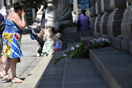 Foto de Ataques de Nottingham: Un miembro mira las flores dejadas en las escaleras del edificio de la Casa del Consejo en el centro de la ciudad hoy después de los ataques de ayer que dejaron 3 personas muertas y 3 heridas Nottingham, Reino Unido, 13 de junio de 2023 - Imagen libre de derechos