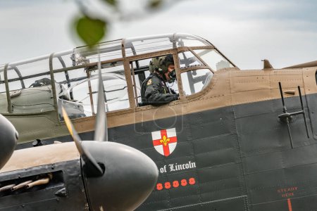Téléchargez les photos : Le chef d'escadron Chris Fairley commence les vérifications de démarrage sur le Lancaster alors que le vol commémoratif de la bataille d'Angleterre et les escadrons du typhon Coningsby de la RAF se préparent pour le survol de Trooping the color à la RAF Coningsby, Coningsby, Royaume-Uni, le 17 juin 2023 - en image libre de droit