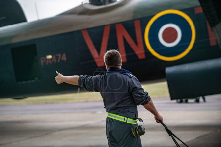Photo for Ground crew prepare the Lancaster as the Battle of Britain memorial flight and RAF Coningsby typhoon squadrons prepare for the flypast for Trooping the colour at RAF Coningsby, Coningsby, United Kingdom, 17th June 2023 - Royalty Free Image