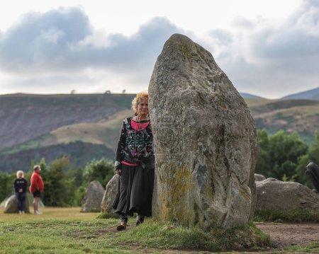 Téléchargez les photos : Une personne médite à l'intérieur du cercle de pierre lors de la célébration du solstice d'été du cercle de pierre de Castlerigg, Royaume-Uni, 20 juin 2023 - en image libre de droit