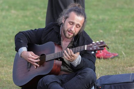 Téléchargez les photos : Une personne joue de la guitare pendant le Castlerigg Stone Circle Summer Solstice Celebration, Royaume-Uni, 20 juin 2023 - en image libre de droit