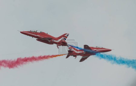 Téléchargez les photos : Royal Air Force Aerobatic Team La paire de 6 et 7 rouges de Red Arrows se croisent, lors du Rhyl Air Show 2023 à Rhyl Seafront, Rhyl, Royaume-Uni, le 27 août 2023 - en image libre de droit