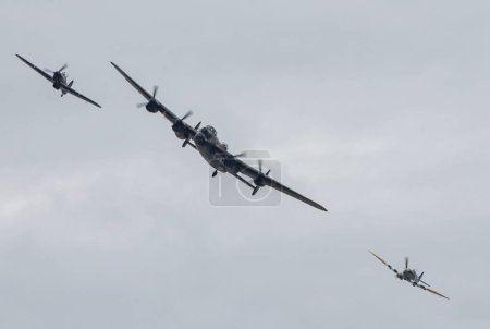 Photo for The Battle of Britain Memorial Flight of Hawker Hurricane PZ865 (left) , Lancaster bomber PA474 (centre) and Mk Vb Spitfire, AB910 (right) perform their display, during Rhyl Air Show 2023 at Rhyl Seafront, Rhyl, United Kingdom, 27th August 2023 - Royalty Free Image