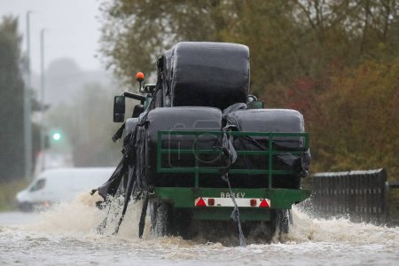 Foto de Un tractor conduce a través de la inundada Barnsdale Road en Leeds después de que el río Aire explota sus orillas mientras Storm Babet golpea el Reino Unido en Allerton Bywater, Allerton Bywater, Reino Unido, 20 de octubre 202 - Imagen libre de derechos