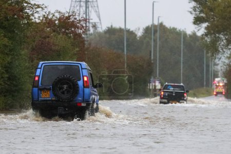 Photo for Two vehicles brave the flooded Barnsdale Road in Leeds after the River Aire bursts it's banks as Storm Babet batters the UK at Allerton Bywater, Allerton Bywater, United Kingdom, 20th October 202 - Royalty Free Image