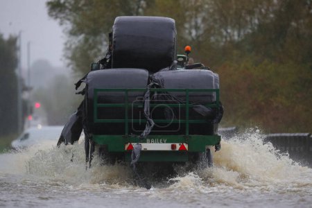 Foto de Un tractor conduce a través de la inundada Barnsdale Road en Leeds después de que el río Aire explota sus orillas mientras Storm Babet golpea el Reino Unido en Allerton Bywater, Allerton Bywater, Reino Unido, 20 de octubre 202 - Imagen libre de derechos