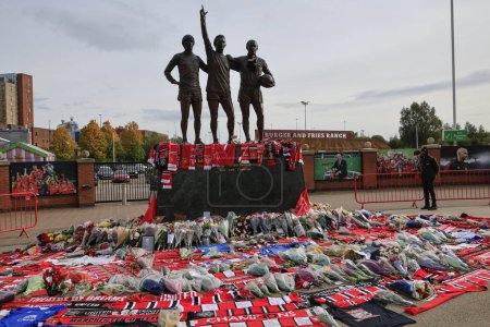 Photo for Flowers laid at the Trinity statue as fans pay tribute to the late Sir Bobby Charlton outside of Old Trafford, Manchester, United Kingdom, 23rd October 2023 - Royalty Free Image