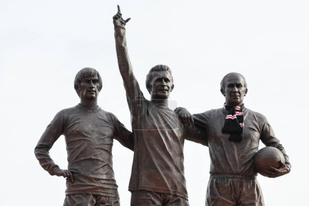 Photo for The Trinity statue as fans pay tribute to the late Sir Bobby Charlton outside of Old Trafford, Manchester, United Kingdom, 23rd October 2023 - Royalty Free Image