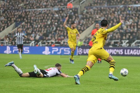 Photo for Ramy Bensebaini #5 of Borussia Dortmund reacts after Kieran Trippier #2 of Newcastle United goes down in the penalty area during the UEFA Champions League match Newcastle United vs Borussia Dortmund at St. James's Park, Newcastle, United Kingdom - Royalty Free Image