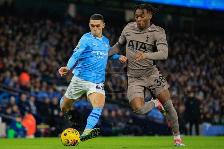 Photo for Phil Foden #47 of Manchester City holds off Destiny Udogie #38 of Tottenham Hotspur during the Premier League match Manchester City vs Tottenham Hotspur at Etihad Stadium, Manchester, United Kingdom, 3rd December 2023 - Royalty Free Image