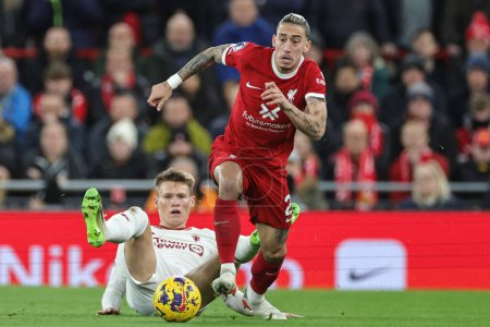 Photo for Kostas Tsimikas of Liverpool breaks with the ball as Scott McTominay of Manchester United watches from the floor during the Premier League match Liverpool vs Manchester United at Anfield, Liverpool, United Kingdom, 17th December 202 - Royalty Free Image