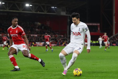 Photo for Son Heung-Min #7 of Tottenham Hotspur holds the ball as Willy Boly #30 of Nottingham Forest tracks him during the Premier League match Nottingham Forest vs Tottenham Hotspur at City Ground, Nottingham, United Kingdom, 15th December 202 - Royalty Free Image