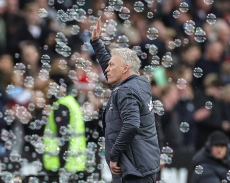 Photo for David Moyes manager of West Ham United waves to the fans in a sea of bubbles after West Ham win 2-0 during the Premier League match West Ham United vs Manchester United at London Stadium, London, United Kingdom, 23rd December 202 - Royalty Free Image