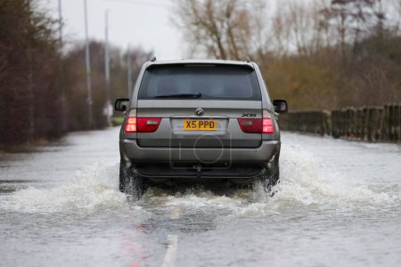 Photo for A car makes its way through the flooded road caused by storms and heavy rain on the A656 near Leeds at Barnsdale Road A656, Allerton Bywater, Castleford, United Kingdom, 2nd January 2023 - Royalty Free Image