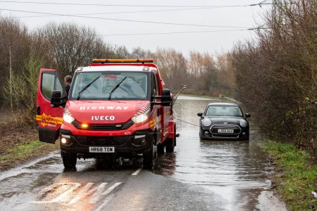 Téléchargez les photos : Une camionnette de récupération tire une voiture coincée sur la route inondée causée par des tempêtes et de fortes pluies près de Leeds sur Newton Lane, Fairburn, Castleford, Royaume-Uni, 2 janvier 2023 - en image libre de droit