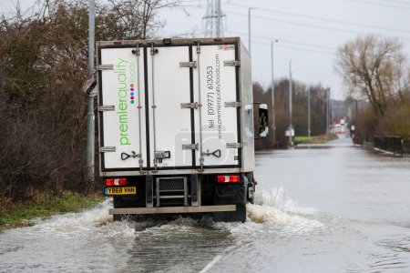 Photo for A lorry makes its way through the flooded road caused by storms and heavy rain on the A656 near Leeds at Barnsdale Road A656, Allerton Bywater, Castleford, United Kingdom, 2nd January 2023 - Royalty Free Image