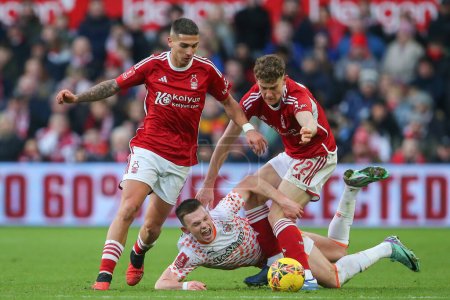Photo for Andy Lyons of Blackpool goes down under a challenge from Ryan Yates of Nottingham Forest during the Emirates FA Cup Third Round match Nottingham Forest vs Blackpool at City Ground, Nottingham, United Kingdom, 7th January 202 - Royalty Free Image