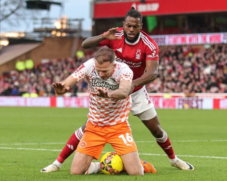 Photo for Jordan Rhodes of Blackpool and Nuno Tavares of Nottingham Forest clash during the Emirates FA Cup  Third Round match Nottingham Forest vs Blackpool at City Ground, Nottingham, United Kingdom, 7th January 202 - Royalty Free Image