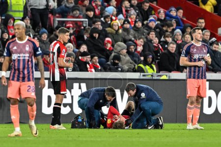 Photo for Mads Roerslev of Brentford receives treatment during the Premier League match Brentford vs Nottingham Forest at The Gtech Community Stadium, London, United Kingdom, 20th January 202 - Royalty Free Image