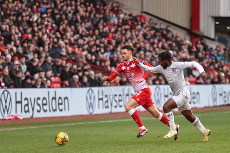 Photo for Jordan Williams of Barnsley breaks with the ball as Dion Rankine of Exeter City tracks him during the Sky Bet League 1 match Barnsley vs Exeter City at Oakwell, Barnsley, United Kingdom, 27th January 202 - Royalty Free Image