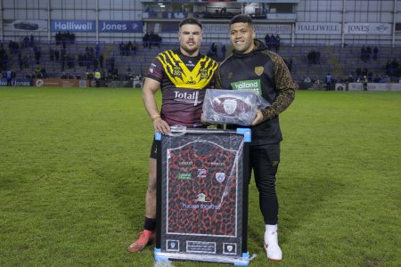 Photo for John Asiata of Leigh Leopards presents a signed Leigh Leopards shirt and ball to Joe Philbin of Warrington Wolves after the Rugby League Joe Philbin Testimonial match Warrington Wolves vs Leigh Leopards at Halliwell Jones Stadium, Warrington, United - Royalty Free Image