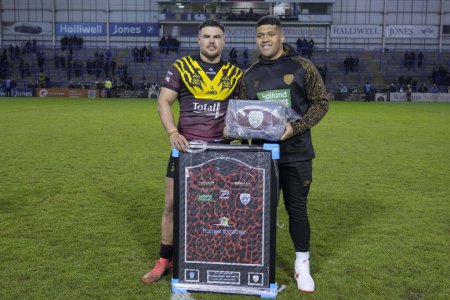 Photo for John Asiata of Leigh Leopards presents a signed Leigh Leopards shirt and ball to Joe Philbin of Warrington Wolves after the Rugby League Joe Philbin Testimonial match Warrington Wolves vs Leigh Leopards at Halliwell Jones Stadium, Warrington, United - Royalty Free Image
