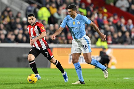 Photo for Rodri of Manchester City breaks with the ball pressured by Neal Maupay of Brentford during the Premier League match Brentford vs Manchester City at The Gtech Community Stadium, London, United Kingdom, 5th February 202 - Royalty Free Image
