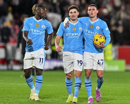 Photo for Jrmy Doku of Manchester City, Julin lvarez of Manchester City and Phil Foden of Manchester City after Manchester City win 1-3 during the Premier League match Brentford vs Manchester City at The Gtech Community Stadium, London, United Kingdom - Royalty Free Image