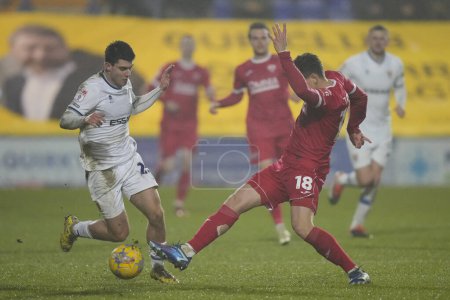 Photo for Jake Taylor of Morecambe attempts a tackle on Rob Apter of Tranmere Rovers during the Sky Bet League 2 match Tranmere Rovers vs Morecambe at Prenton Park, Birkenhead, United Kingdom, 13th February 202 - Royalty Free Image