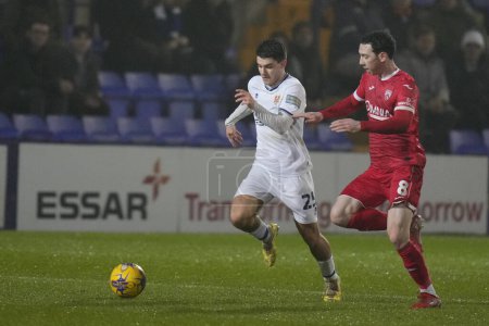 Photo for Rob Apter of Tranmere Rovers makes a break past Joe Adams of Morecambe during the Sky Bet League 2 match Tranmere Rovers vs Morecambe at Prenton Park, Birkenhead, United Kingdom, 13th February 202 - Royalty Free Image