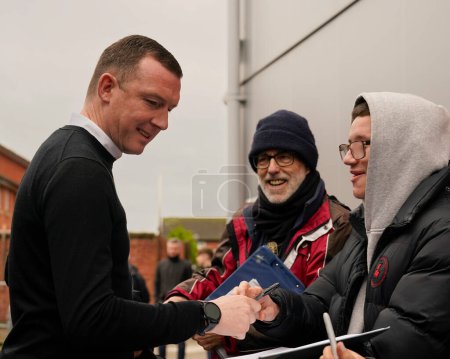 Téléchargez les photos : Neill Collins, manager de Barnsley signe un autographe pour un fan alors qu'il arrive au stade avant le match de Sky Bet League 1 Fleetwood Town vs Barnsley au Highbury Stadium, Fleetwood, Royaume-Uni, 17 février 202 - en image libre de droit