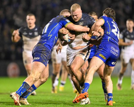 Photo for Jack Ashworth Hull FC is tackled by Adam Holroyd of Warrington Wolves and Ben Currie of Warrington Wolves, during the Betfred Super League Round 2 match Warrington Wolves vs Hull FC at Halliwell Jones Stadium, Warrington, United Kingdom, 23rd Februar - Royalty Free Image