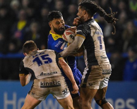 Photo for Zane Musgrove of Warrington Wolves is tackled by Jayden Okunbor Hull FC and Jordan Lane Hull FC during the Betfred Super League Round 2 match Warrington Wolves vs Hull FC at Halliwell Jones Stadium, Warrington, United Kingdom, 23rd February 202 - Royalty Free Image