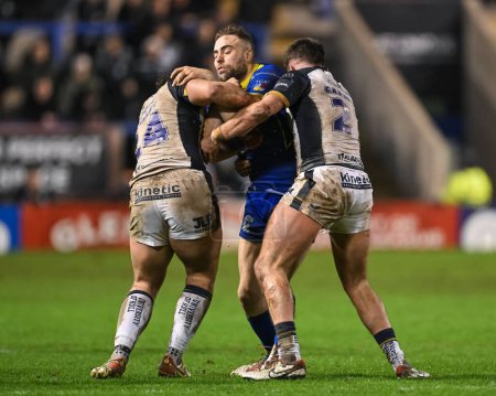 Photo for James Harrison of Warrington Wolves is tackled by Liam Tindall Hull FC and Nick Staveley Hull FC during the Betfred Super League Round 2 match Warrington Wolves vs Hull FC at Halliwell Jones Stadium, Warrington, United Kingdom, 23rd February 202 - Royalty Free Image