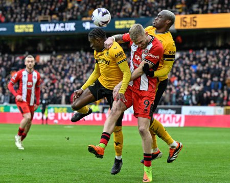 Photo for Jean-Ricner Bellegarde of Wolverhampton Wanderers jumps up to win the high ball from Oliver McBurnie of Sheffield United during the Premier League match Wolverhampton Wanderers vs Sheffield United at Molineux, Wolverhampton, United Kingdom, 25th Febr - Royalty Free Image