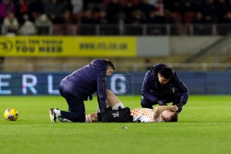Photo for Andy Lyons of Blackpool is attended to by medics during the Sky Bet League 1 match Leyton Orient vs Blackpool at Matchroom Stadium, London, United Kingdom, 27th February 202 - Royalty Free Image