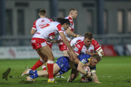 Photo for Matt Dufty of Warrington Wolves is tackled by Jai Whitbread of Hull KR during the Betfred Super League Round 4 match Hull KR vs Warrington Wolves at Sewell Group Craven Park, Kingston upon Hull, United Kingdom, 7th March 202 - Royalty Free Image