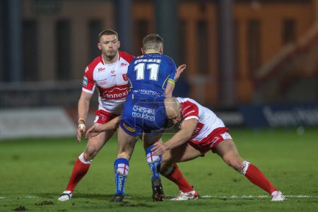 Photo for Ben Currie of Warrington Wolves is tackled by Dean Hadley of Hull KR during the Betfred Super League Round 4 match Hull KR vs Warrington Wolves at Sewell Group Craven Park, Kingston upon Hull, United Kingdom, 7th March 202 - Royalty Free Image