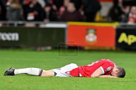 Photo for Paul Mullin of Wrexham reacts to missing a late chance on goal, during the Sky Bet League 2 match Wrexham vs Harrogate Town at SToK Cae Ras, Wrexham, United Kingdom, 12th March 202 - Royalty Free Image