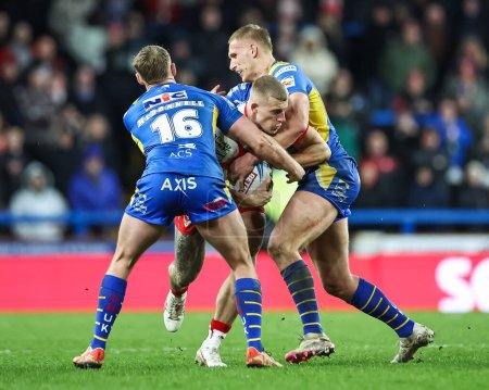 Photo for Jake Wingfield of St. Helens is tackled by James McDonnell of Leeds Rhinos and Mikolaj Oledzki of Leeds Rhinos during the Betfred Super League Round 5 match Leeds Rhinos vs St Helens at Headingley Stadium, Leeds, United Kingdom, 15th March 202 - Royalty Free Image