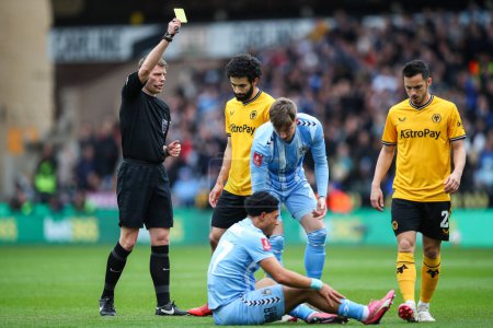 Photo for Rayan At-Nouri of Wolverhampton Wanderers is shown a yellow card by referee Samuel Barrott for a foul on Milan van Ewijk of Coventry City during the Emirates FA Cup Quarter- Final match Wolverhampton Wanderers vs Coventry City at Molineux - Royalty Free Image